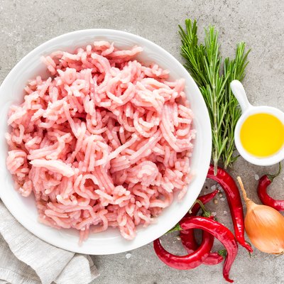 Mince. Ground turkey meat with ingredients for cooking on light grey background. Top view