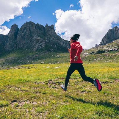 Woman ultra marathon trail runner running on beautiful mountains