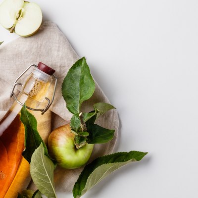 Close-Up Of Apple Cider Vinegar In Bottle Against White Background