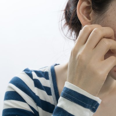 asian young woman scratching face on isolated white background