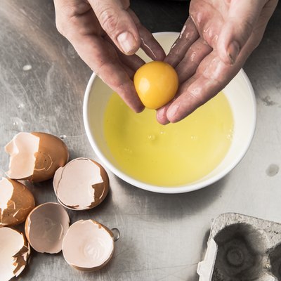 Hands holding egg yolk