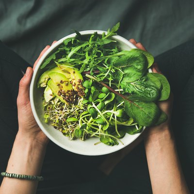Breakfast with spinach, arugula, avocado, seeds and sprouts in bowl