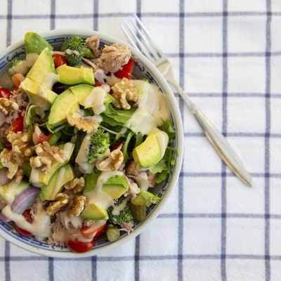 Tuna and avocado salad with walnuts on striped tablecloth for a keto diet