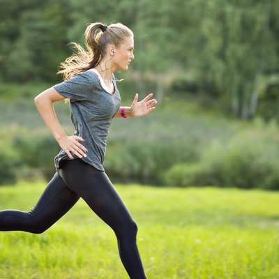 Woman listening to music and running in park