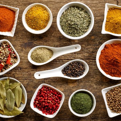 Top view of several white bowls holding a variety of spices