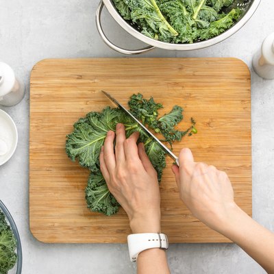 Top down view of fresh kale leaves cut on a cutting board