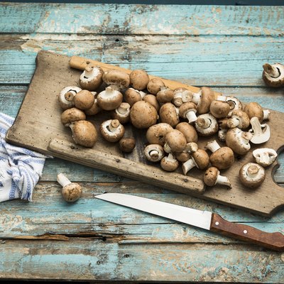 Crimini mushrooms on wooden chopping board