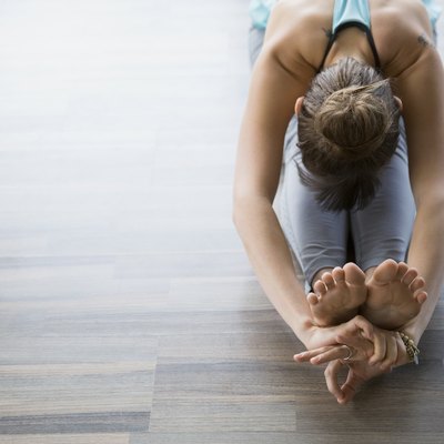 Woman in seated forward bend practicing mudra yoga