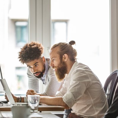 Businessmen discussing over laptop in office