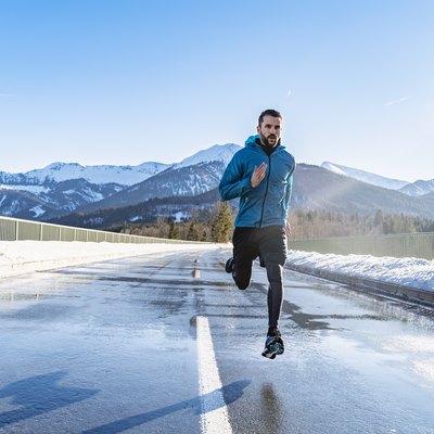 Germany, Bavaria, sportive man running on a road in winter
