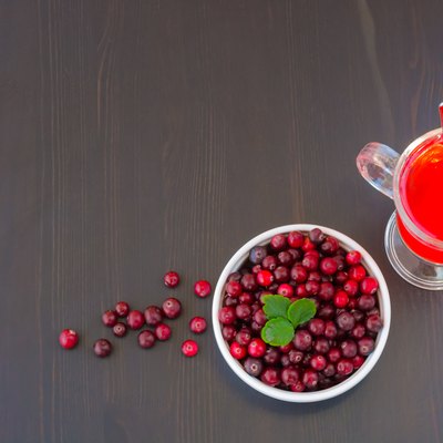 Glass of cranberry juice and a bowl of cranberries