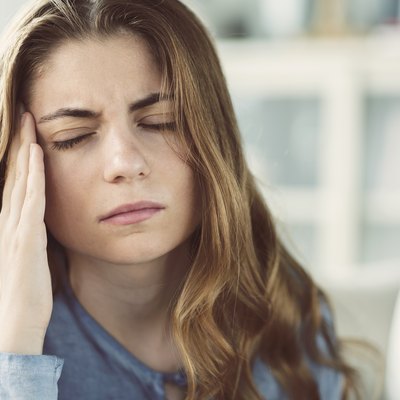 Young woman with headache in home interior