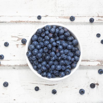 Bowl of blueberries on white wood