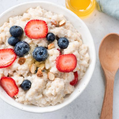 Oatmeal porridge with berries and almonds in bowl, top view