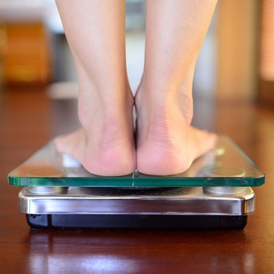 A view from the back of feet on a bathroom scale