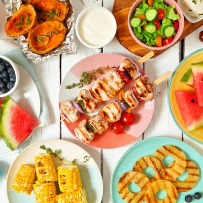 Summer BBQ or picnic food flat lay table scene over white wood