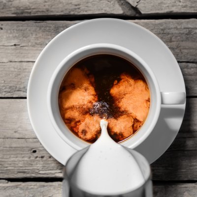 Pouring milk into coffee cup