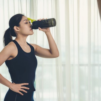 A woman holding a bottle of protein supplements on muscle drink to strengthen health care to vigorous and beautiful.