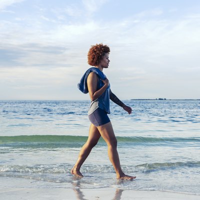 young female walks along beach