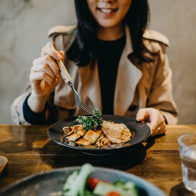 Smiling young woman enjoying dinner date with friends in a restaurant