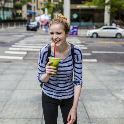 Young woman drinking green juice, a healthy alternative to energy drinks
