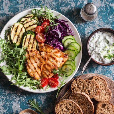 Grilled chicken breast, zucchini and garden vegetable power bowl. Healthy diet food concept, top view