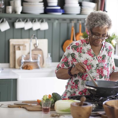 Active senior woman cooking in kitchen
