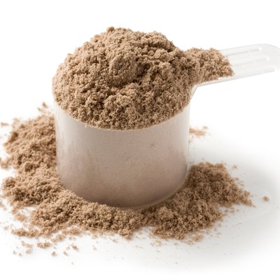 Measuring scoop of protein powder on a white background