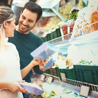 Couple shopping in supermarket for cheap meal plans