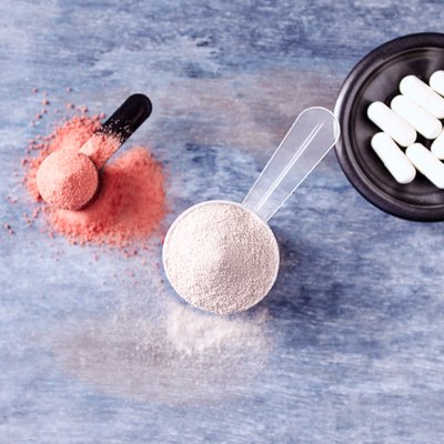 Scoop of Whey Protein, Creatine Powder and Taurine Capsules. Sport nutrition. Rustic wooden background. Directly Above. Copy space
