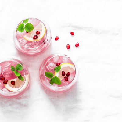 Pomegranate tequila cocktail. Summer light alcoholic drink, cooling aperitif. On light background, top view, free space. Flat lay