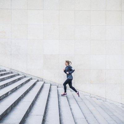 Caucasian woman running up staircase