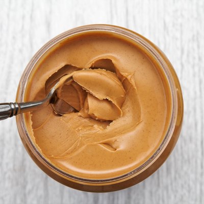 Peanut butter on spoon in jar
