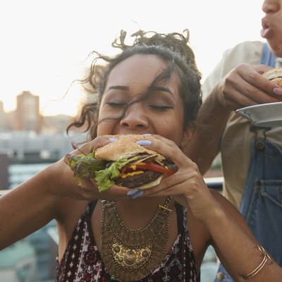 Rooftop BBQ with woman eating a burger