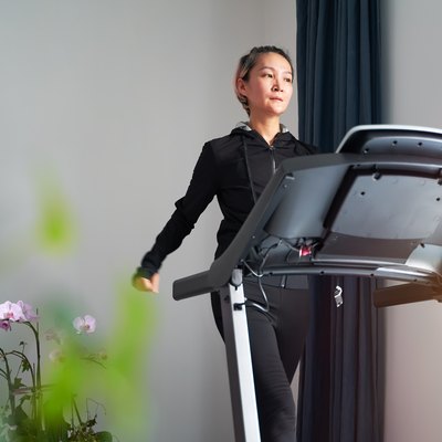 Asian woman exercising on treadmill home gym