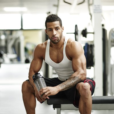Bodybuilder sitting on a bench at the gym