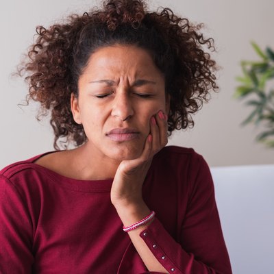 Woman feeling toothache and massaging gums