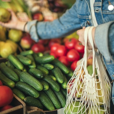 Vegetables and fruit in reusable bag on a farmers market, zero waste concept