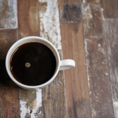 Black coffee in white cup on wooden table