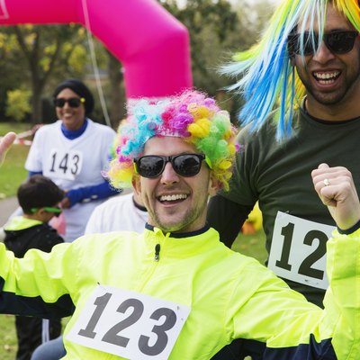Portrait enthusiastic male runners wearing wigs at charity run