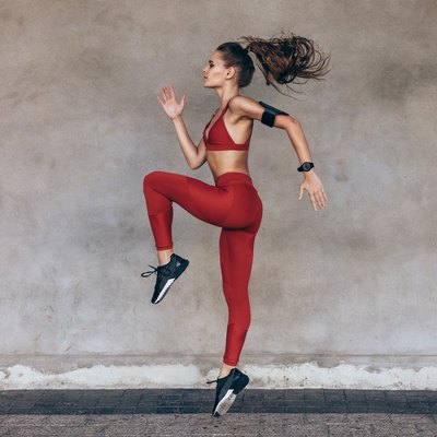 Sportswoman jumping and stretching