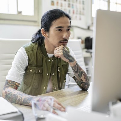 Businessman with tattoo using computer at desk