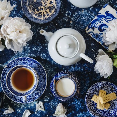 Tea setting with english tea, flowers, biscuits, sugar, books and a tea pot