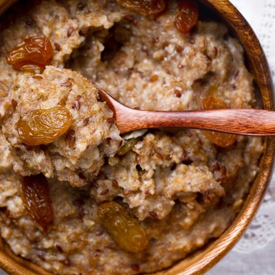 Oatmeal with flax seeds and raisins in a wooden bowl