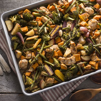 Top view of a sheet pan with slow-carb foods including chicken and vegetables