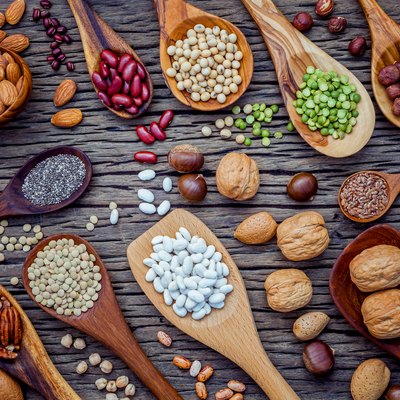 Various legumes and different kinds of nutshells in spoons. Waln