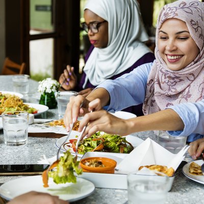 Islamic women friends dining together with happiness