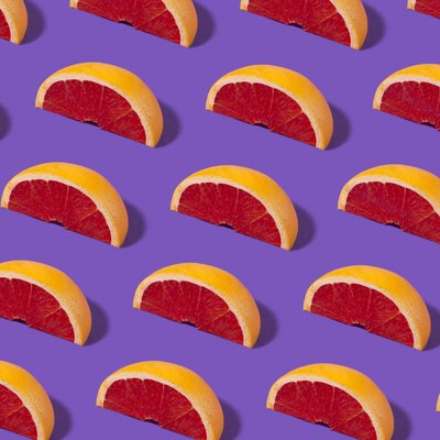 Slices of grapefruit in a pattern on a purple background