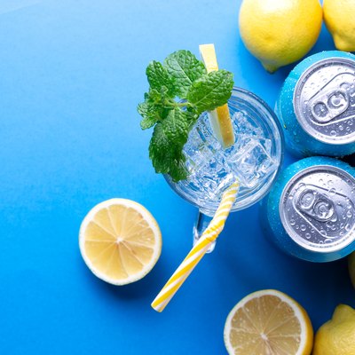 Soda drink with lemon and aluminium cans