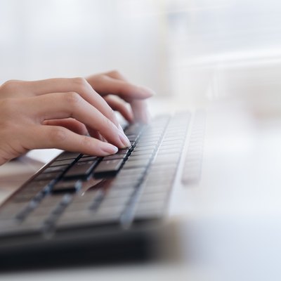 Hispanic businesswoman typing on keyboard